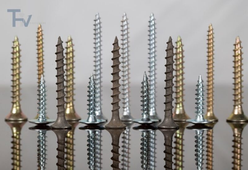 Các loại vít tự ren (self tapping screws) của THV Fasteners với nhiều màu sắc và kích thước khác nhau, được sắp xếp thẳng đứng trên bề mặt phản chiếu.