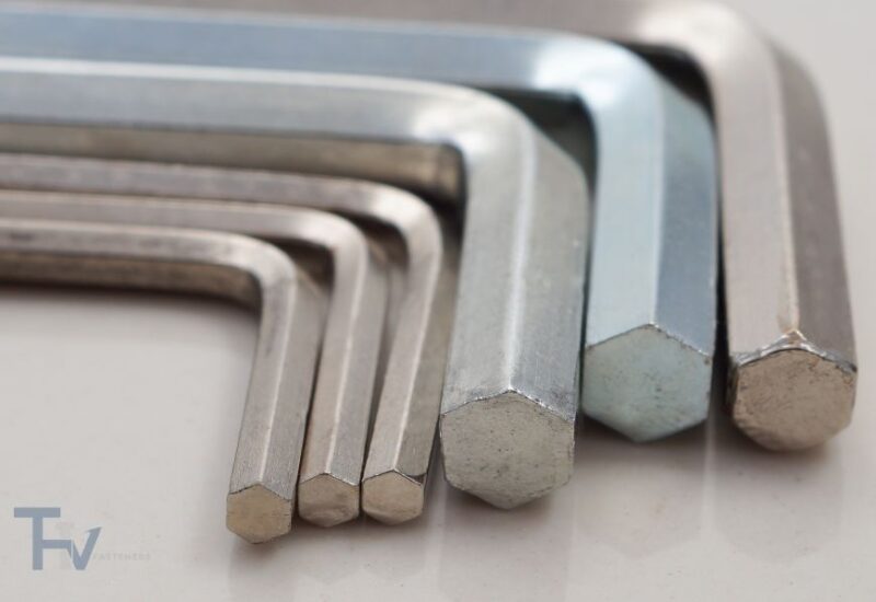 A diverse collection of THV Fasteners' hex key sets, including chrome-plated and black-finished Allen keys, arranged on a gradient grey background for industrial and mechanical use.