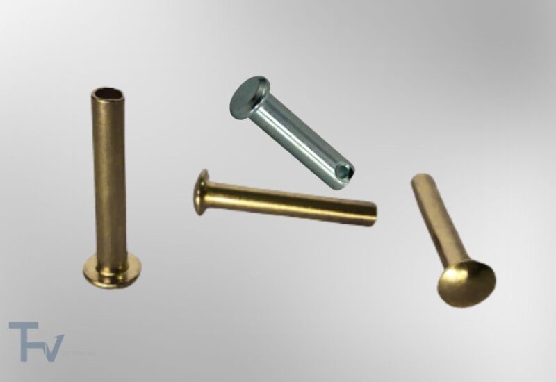 Bức ảnh này thể hiện một bộ sưu tập các loại đinh tán (rivets) và chốt (pins) công nghiệp, được sắp xếp một cách nghệ thuật trên nền tối.